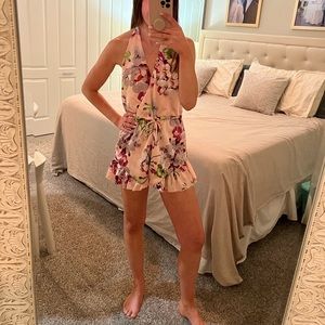 Pink floral romper with halter top and open back.brand is by the way. Size small